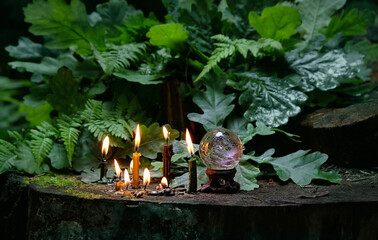 Wall Mural - candles and magic crystal ball in dark forest, natural background. meditation, relaxation, Witchcraft concept. healing gemstone. spiritual ritual for cleaning aura. wiccan witch altar