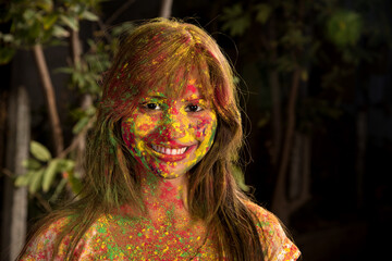 Portrait of a happy young girl on the festival of colors Holi. Girl posing and celebrating the festival of colors.