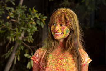 Portrait of a happy young girl on the festival of colors Holi. Girl posing and celebrating the festival of colors.