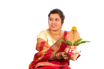 Indian Traditional Woman performing worship with copper kalash, Indian Festival, copper kalash with coconut and mango leaf with floral decoration, essential in hindu puja.