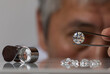 © EgolenaHK - Close up of diamond dealer's hands evaluating diamond at international jewelry exhibition. High quality photo
