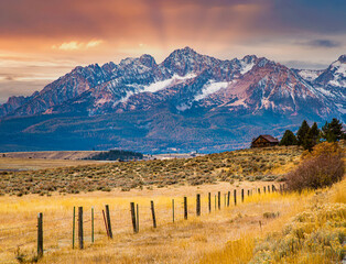 Wall Mural - The Sawtooth mountains and a log cabin at sunrise and highway 75 leading to Stanley, Idaho.