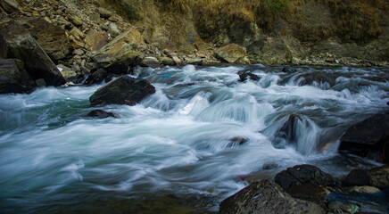 Poster - Closeup shot of a babbling river through rocks in a forest