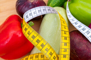 Wall Mural - Top view of measuring tape and vegetables on a wooden cutting board