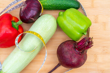 Wall Mural - Top view of measuring tape and vegetables on a wooden cutting board