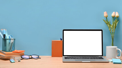 Mock up laptop on wooden table at stylish workplace.