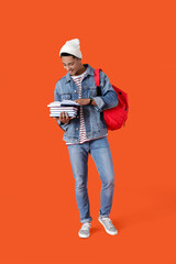 Canvas Print - Male African-American student with books on color background