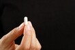 © Shisanupong - woman holding a white pill for health, cure disease