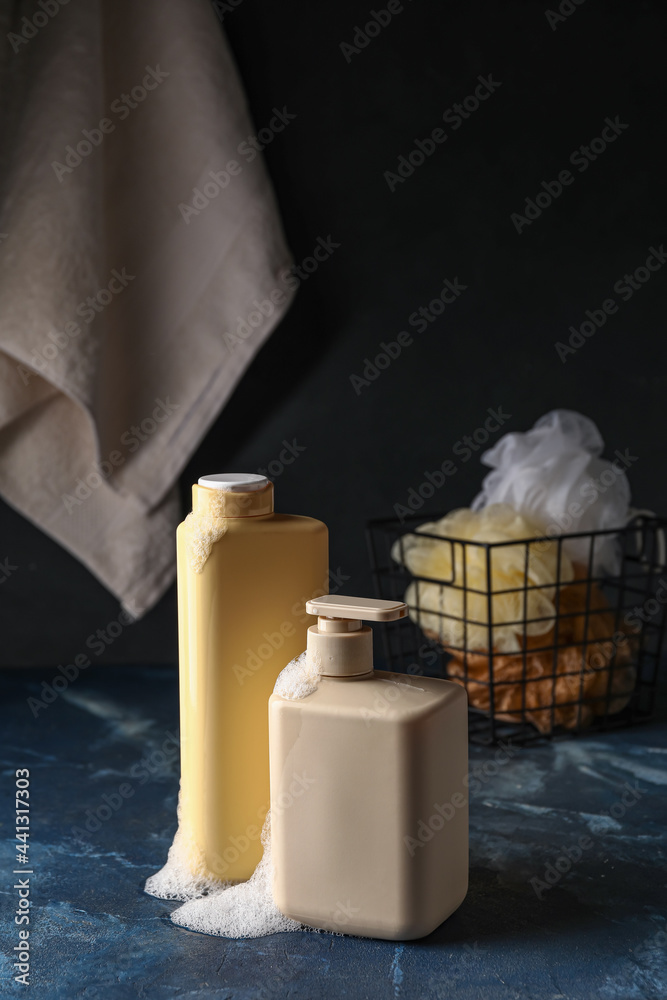 Bottles of cosmetic products on dark background
