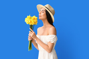 Wall Mural - Beautiful young woman with  narcissus bouquet on color background