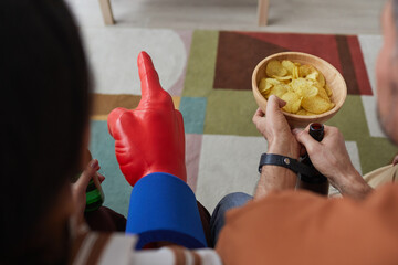 Wall Mural - Top view close up of sports fans holding snacks while watching game match together, copy space