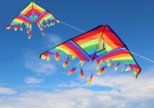 Two Colorful Kites Flying High In The Sky With Brightly Colored