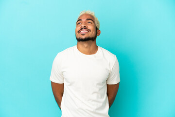 Sticker - Young Colombian handsome man isolated on blue background thinking an idea while looking up