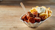 Delicious curried sausage chunks with fries and sauces in bowl