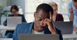 © TommyStockProject - Close up portrait of tired afro-american businessman using laptop working in open space office