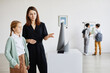 © Seventyfour - Portrait of mother and daughter looking at sculptures in modern art gallery, copy space