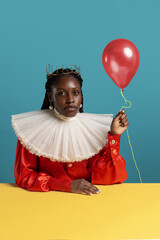 Wall Mural - Portrait of African young woman in bright red vintage dress with big white collar posing isolated on blue background. Concept of comparison of eras, fashion, humor, ad.