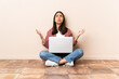 © luismolinero - Young mixed race woman with a laptop sitting on the floor stressed overwhelmed