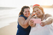 © DisobeyArt - Curvy women friends taking selfie on the beach during summer vacation - Soft focus on right woman face