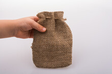 Closeup Shot Of A Person Holding A Gunny Sack Over A White Background