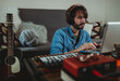 © ADDICTIVE STOCK - Musician using synthesizer and laptop at home