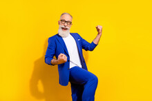 Photo Portrait Of Bearded Man In Spectacles Blue Suit Gesturing Like Winner Isolated Bright Yellow Color Background