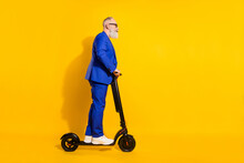 Full Size Profile Side Photo Of Mature Businessman Riding Ecological Scooter Isolated On Yellow Color Background