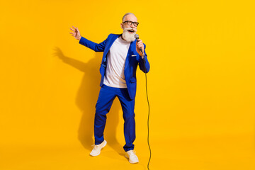 Poster - Full size photo of happy cheerful good mood mature businessman singing karaoke isolated on yellow color background