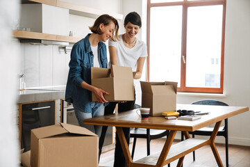 A positive lesbian couple sorting boxes after moving