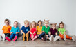 © oksix - Cheerful children sitting on a floor near the wall