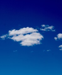 the bright blue sky with the white fluffy clouds.