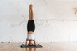 Young brunette white woman headstand