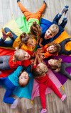 Fototapeta Kwiaty - Cheerful children playing team building games on a floor