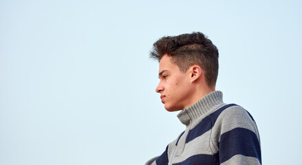 A portrait of an attractive Hispanic male against a blue sky