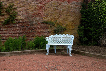 White Metal Bench In A Country House Garden