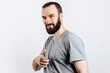 © Daria Lukoiko - Portrait of cheerful young handsome man smiling looking at camera pointing finger forward on white background with space for advertising mock up