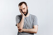 © Daria Lukoiko - Portrait of handsome young man frowning while holding hands near head on white background with space for advertising mock up