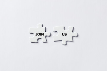 Wall Mural - Two Jigsaw puzzle pieces with the message join us. Business recruitment, hiring or membership