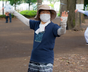 Asian elderly people practicing Tai Chi at public park