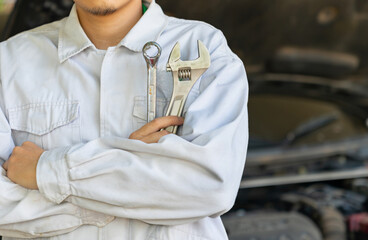 Wall Mural - Cropped shot of auto mechanic with wrench in hands at mechanic shop.