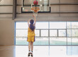 © Austockphoto - girl shooting basketball hoop.