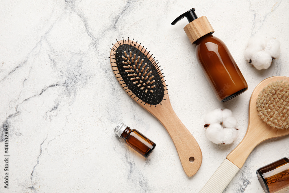 Composition with hair brush and cosmetics on light background