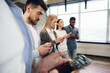 © fotofabrika - Diverse young people colleagues working on mobile phones together in office