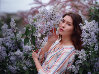 beautiful young asian woman enjoying the blooming of flowers in spring