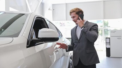 Canvas Print - Happy adult man customer male buyer client wears classic suit talk speak on mobile cell phone chooses auto wants buy new vehicle in car showroom salon dealership store motor show indoor. Sales concept