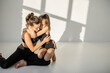 Portrait of a cheerful sports mom and little daughter hug and having fun during sports activities indoors. Close relationships with mother and sports in childhood