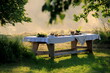 Outdoors summer scene party table on sunset. Old wooden table under trees with food plate. Midsummer celebrating in Latvia, Ligo festive