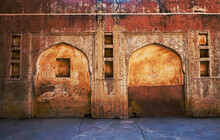 Front View Of A Grunge, Weathered Wall Of Ancient Fort With Arch Design. Details Of Ruins From An Indian Historical Building.