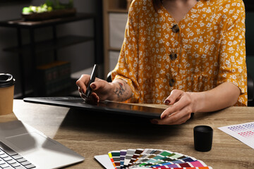 Poster - Professional designer with graphic tablet at wooden table, closeup