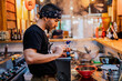 © ADDICTIVE STOCK - Man in bandana standing at counter and cooking ramen